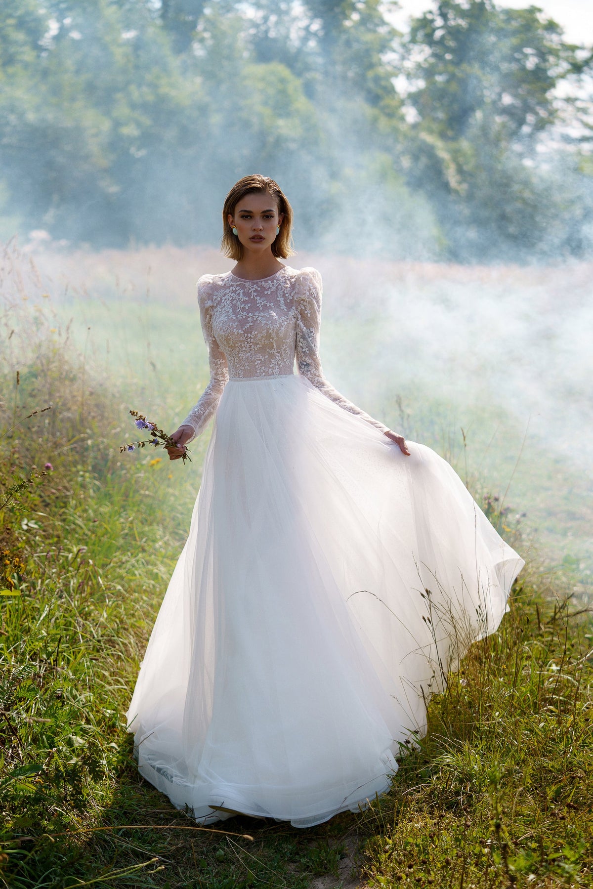 A-line wedding dress with long sleeves and closed back. The top is embroidered with lace.