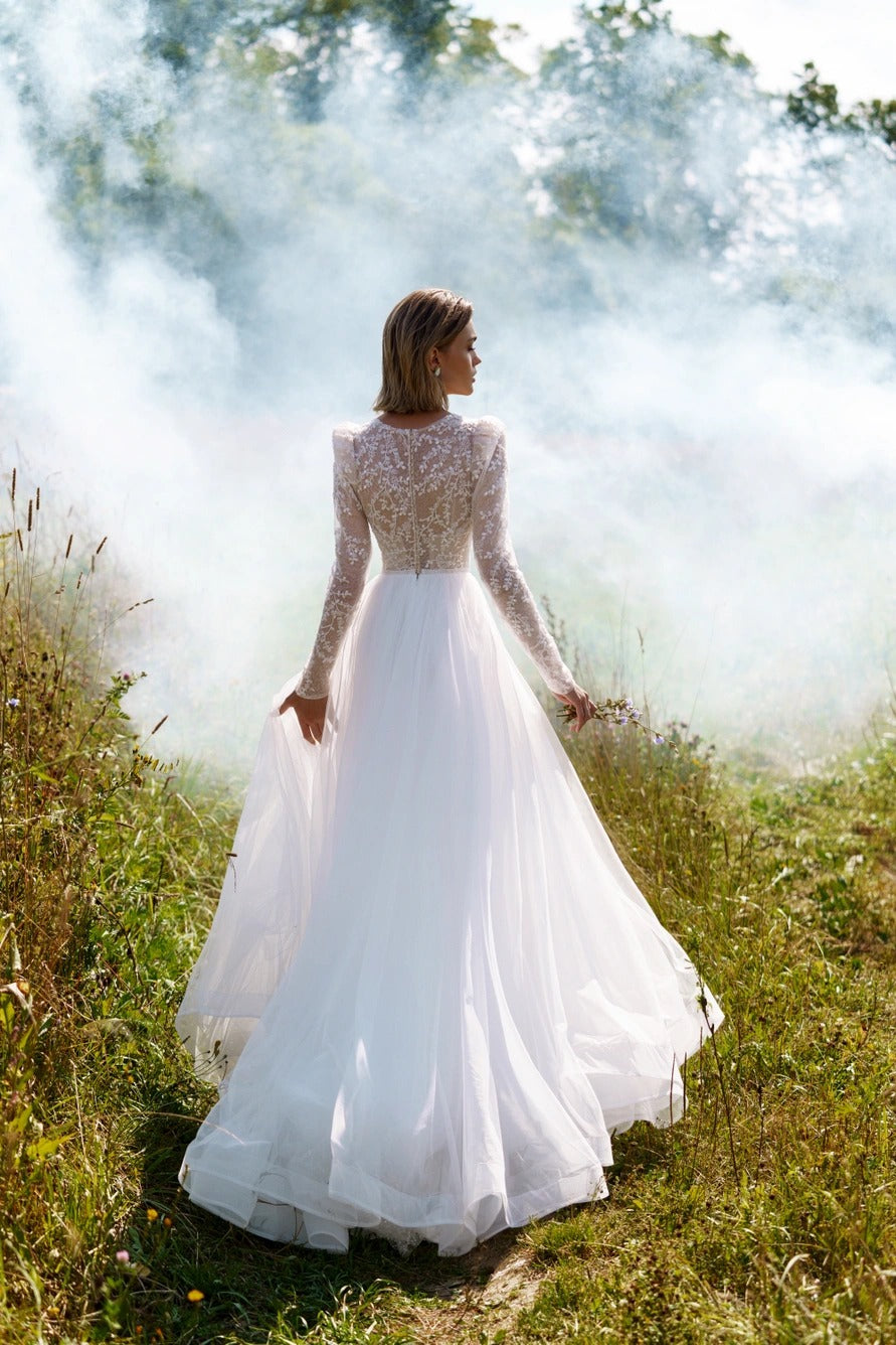 A-line wedding dress with long sleeves and closed back. The top is embroidered with lace.